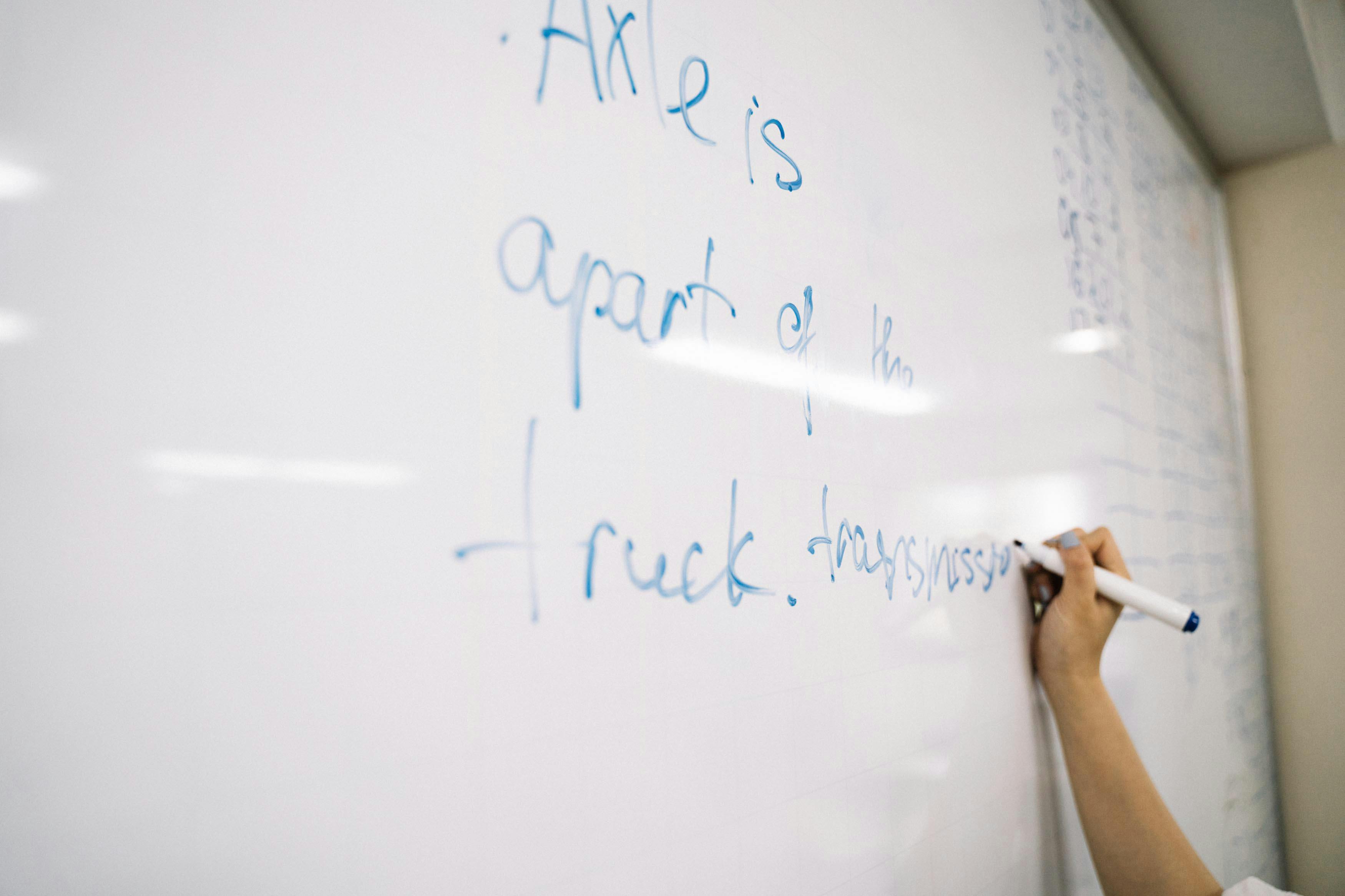 Student working through a problem at a whiteboard